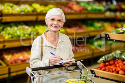Smiling senior woman checking list