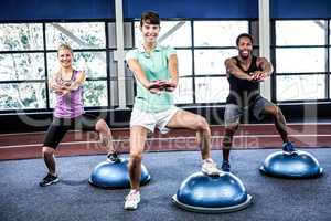 Fit people doing exercise with bosu ball
