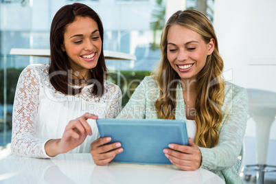 Two girls use a tablet