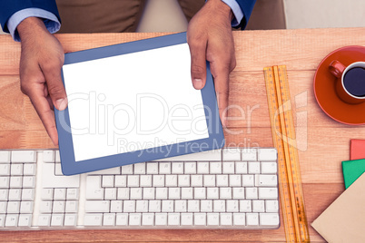 Businessman holding digital tablet while sitting at table