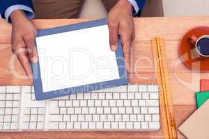 Businessman holding digital tablet while sitting at table