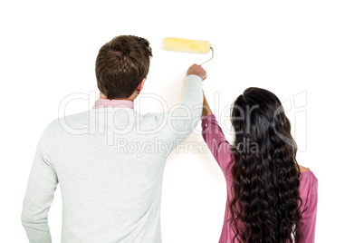 Rear view of couple holding paint roller