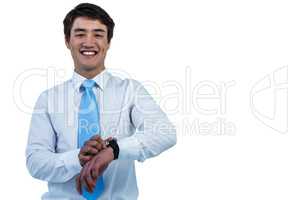 Smiling asian businessman holding his watch