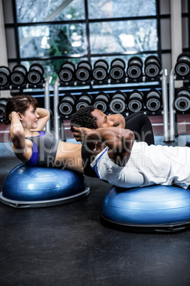 Fit couple doing bosu ball exercises