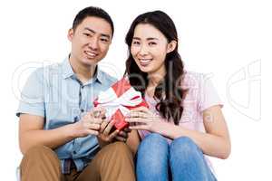 Happy couple holding gift box