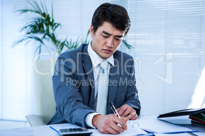 Riled up asian businessman in his desk