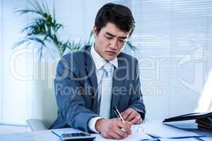 Riled up asian businessman in his desk