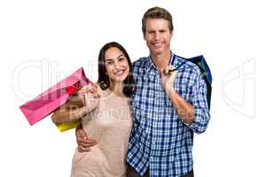 Portrait of cheerful couple with shopping bags