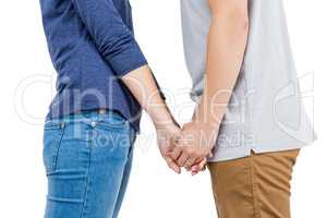 Mid section of couple holding hands