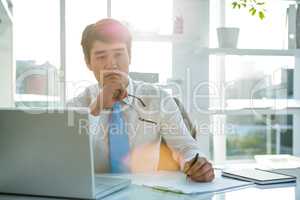 Thoughtful asian businessman at his desk