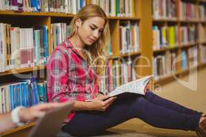 Concentrated female student working on floor