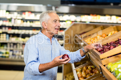 Senior man choosing onions carefully