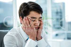 Thoughtful businessman with head in hands