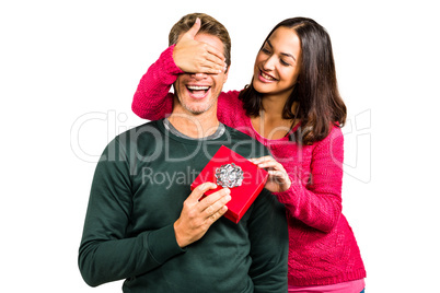 Smiling girlfriend closing eyes of boyfriend