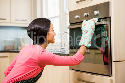 Smiling woman looking in the oven