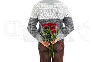 Mid section of man hiding red roses