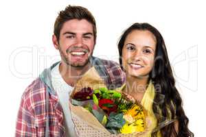 Happy couple holding bouquet and smiling at the camera