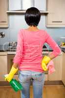 Rear view of standing brunette ready to clean the kitchen