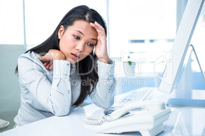 Unsmiling businesswoman with hands on face