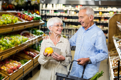 Smiling senior couple holding orange