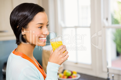 Smiling brunette up to drink orange juice