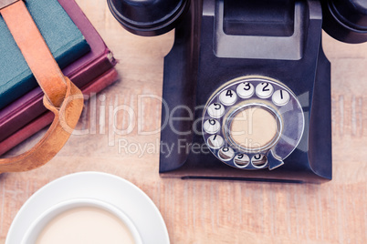 Old landline telephone with diaries and coffee