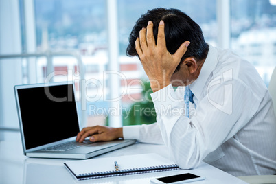Worried businessman working at his desk
