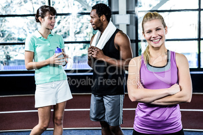 Smiling woman with arms crossed while her friends chatting