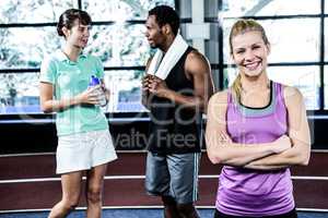 Smiling woman with arms crossed while her friends chatting