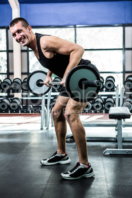 Muscular man exercising with barebell