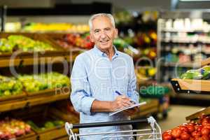 Smiling senior man with grocery list