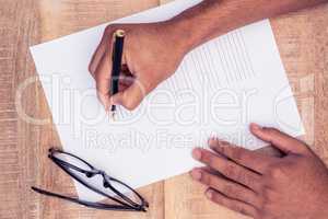 Cropped hand of businessman writing on paper