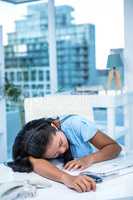 Tired businesswoman sleeping at her desk