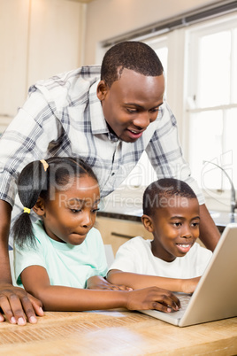 Happy family using laptop in the kitchen