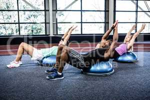 Fit people doing exercise with bosu ball