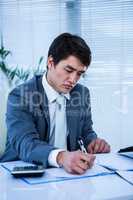 Troubled asian businessman in his desk