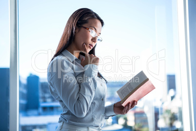Concentrated businesswoman reading book
