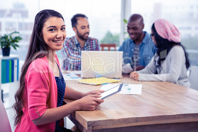 Portrait of cheerful young businesswoman holding digital tablet