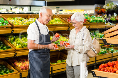 Senior customer and worker discussing vegetables