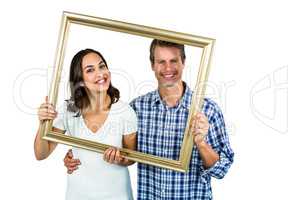 Happy couple looking through picture frame