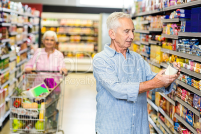 Senior man looking at canned food