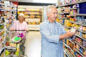 Senior man looking at canned food