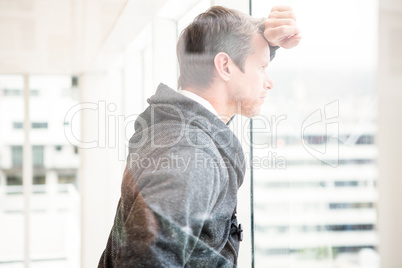 Thoughtful man leaning on glass window
