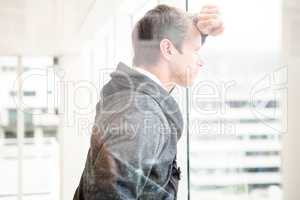 Thoughtful man leaning on glass window