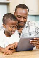 Father and son using tablet together