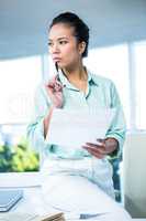 Smiling businesswoman sitting on her desk