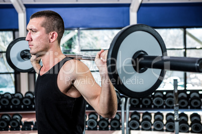 Muscular man exercising with barebell