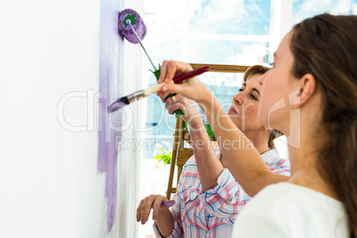 Mother and daughter focused on painting