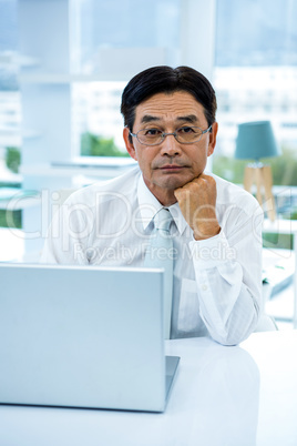 Thoughtful asian businessman looking at the camera