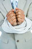 Businessman tied up in rope